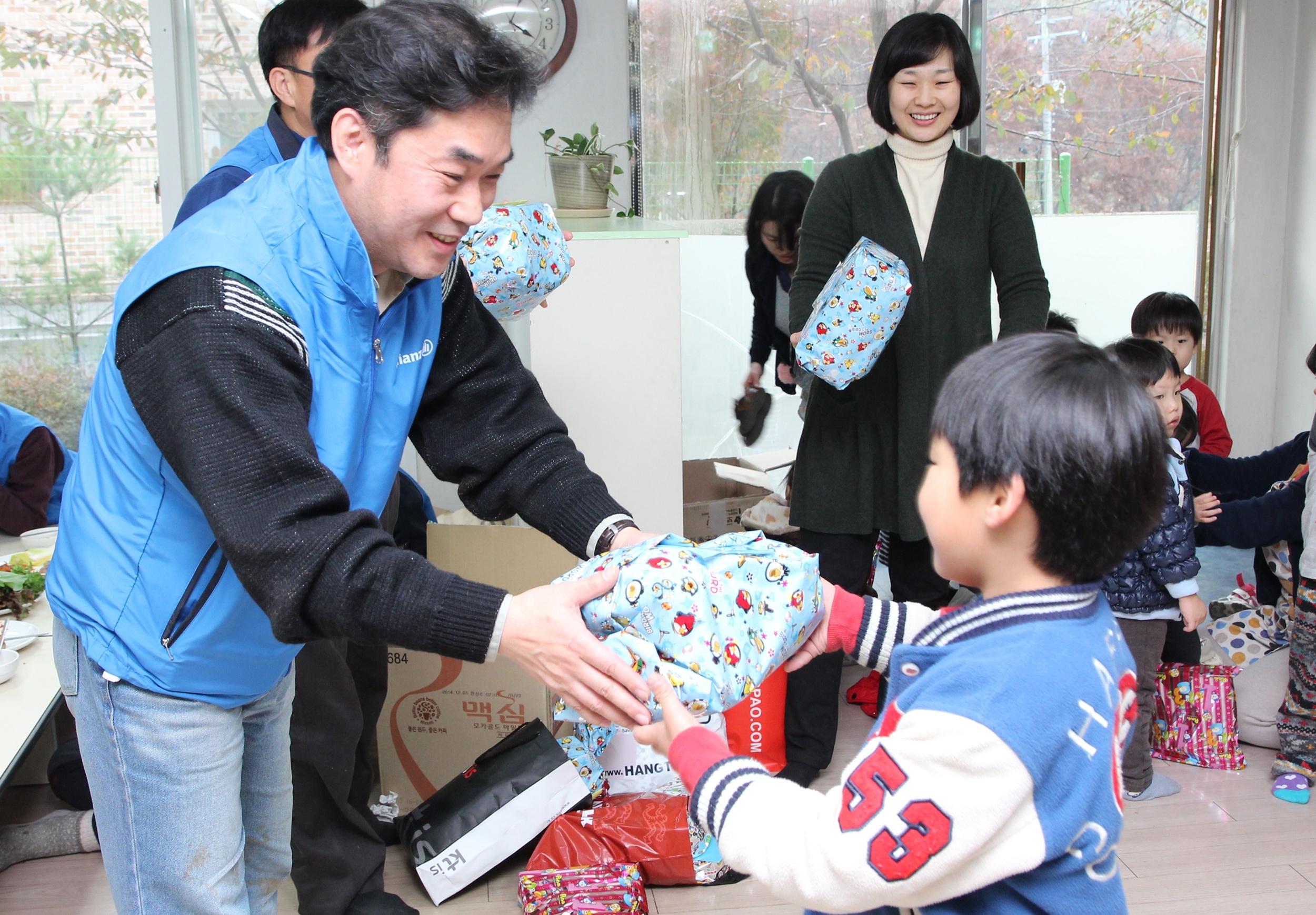 알리안츠생명 직원들이 지온보육원아이들에게 목도리, 장갑 등 미리 준비한 방한물품을 선물하는 모습