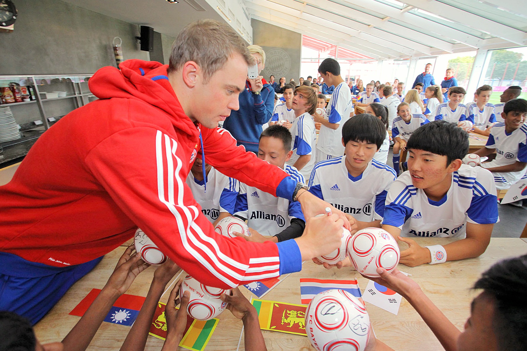 뮌헨에서 개최된 알리안츠 주니어 풋볼 캠프의 한국 참가자들이 FC바이에른 뮌헨 마누엘 노이어 골키퍼로부터 사인을 받고 있는 모습 사진