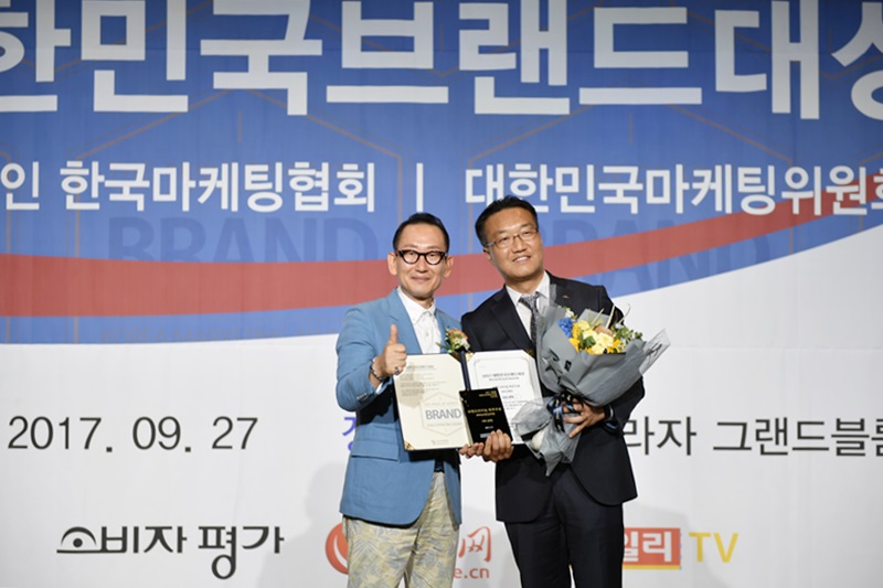 사진 설명: 한국마케팅협회 이해선 회장(좌)과 마켓전략실장 변성현님(우)이 엄지척을 하면서 상장과 꽃다발을 들고 있는 모습